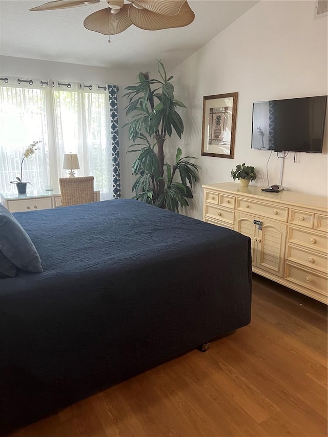 bedroom with dark hardwood / wood-style floors, vaulted ceiling, and ceiling fan