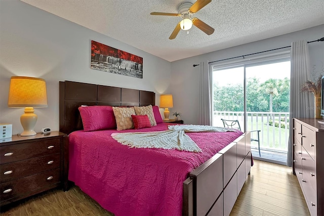 bedroom featuring access to exterior, a textured ceiling, hardwood / wood-style floors, and ceiling fan