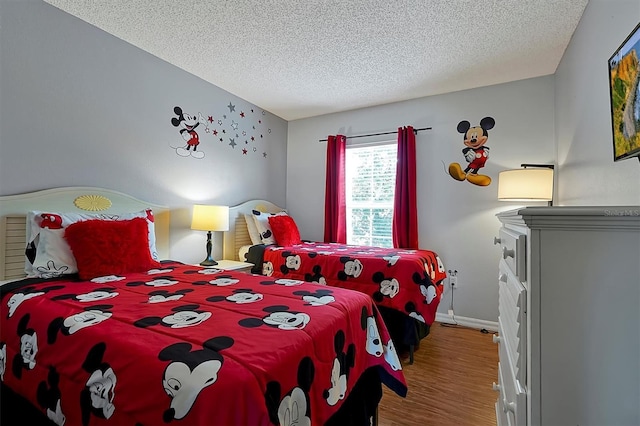 bedroom with wood-type flooring and a textured ceiling