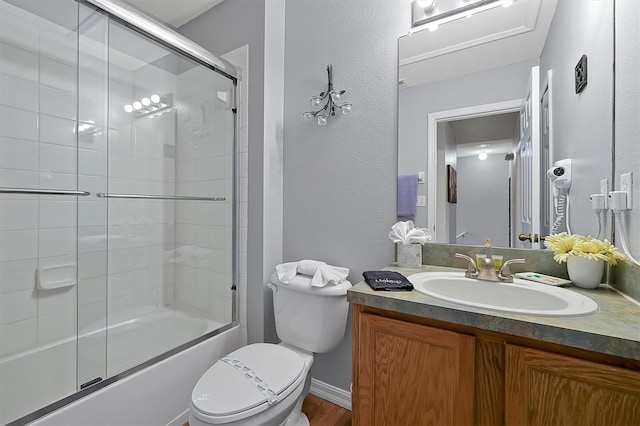 full bathroom featuring vanity, combined bath / shower with glass door, and toilet