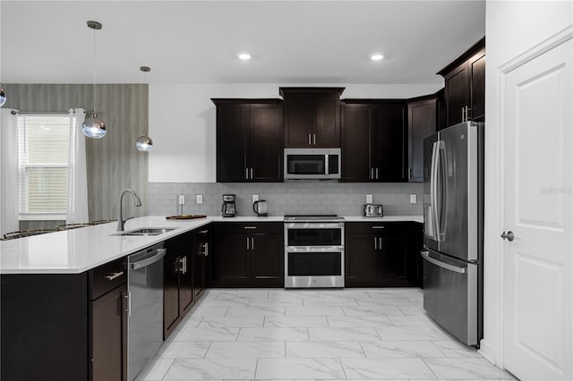 kitchen featuring sink, hanging light fixtures, stainless steel appliances, backsplash, and kitchen peninsula