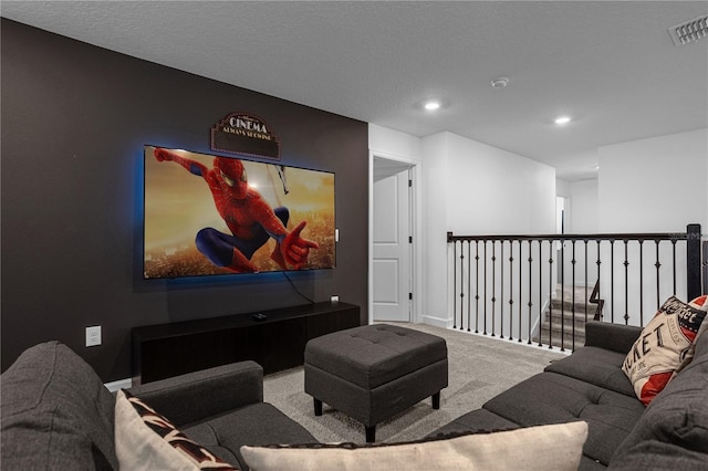 home theater room featuring carpet flooring and a textured ceiling