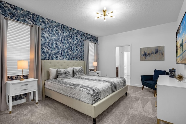 bedroom featuring light carpet, a textured ceiling, and an inviting chandelier