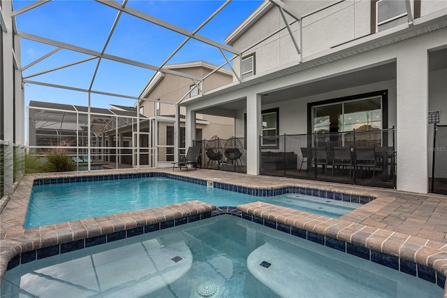 view of pool with a lanai, an in ground hot tub, and a patio