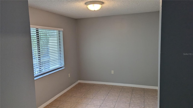 tiled empty room with a textured ceiling