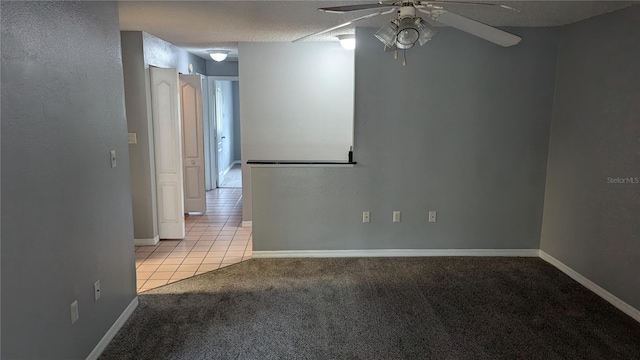 carpeted spare room featuring a textured ceiling and ceiling fan