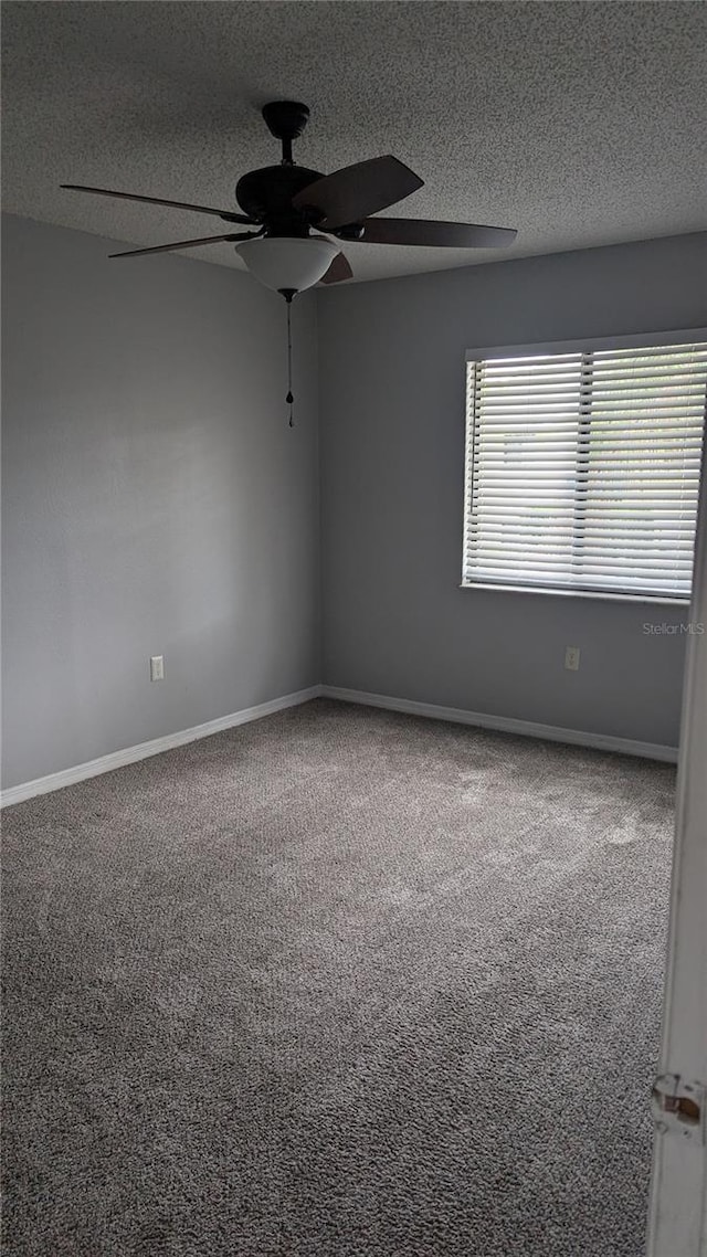 carpeted spare room with a textured ceiling and ceiling fan