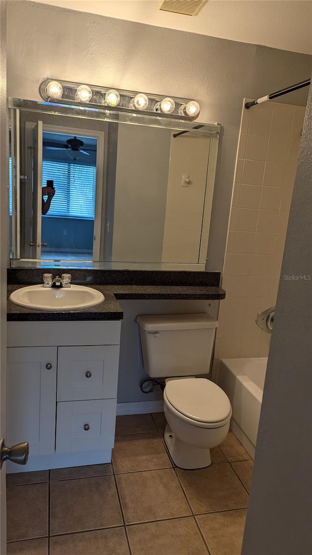 full bathroom featuring tiled shower / bath combo, tile patterned floors, toilet, and vanity