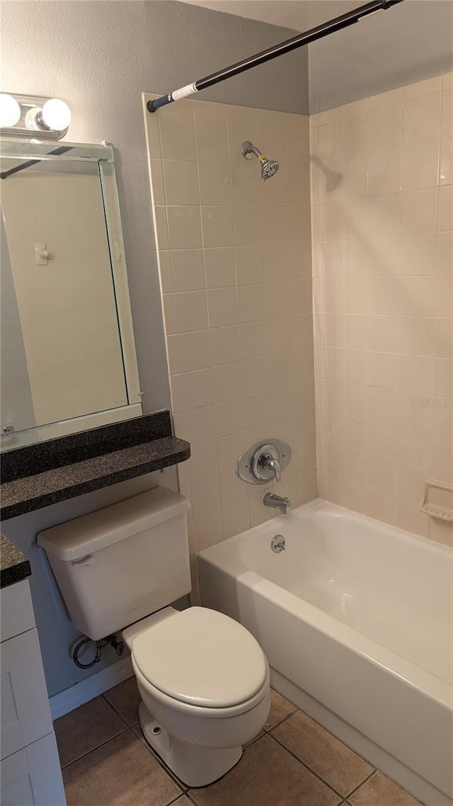 full bathroom with tile patterned flooring, tiled shower / bath combo, toilet, and vanity