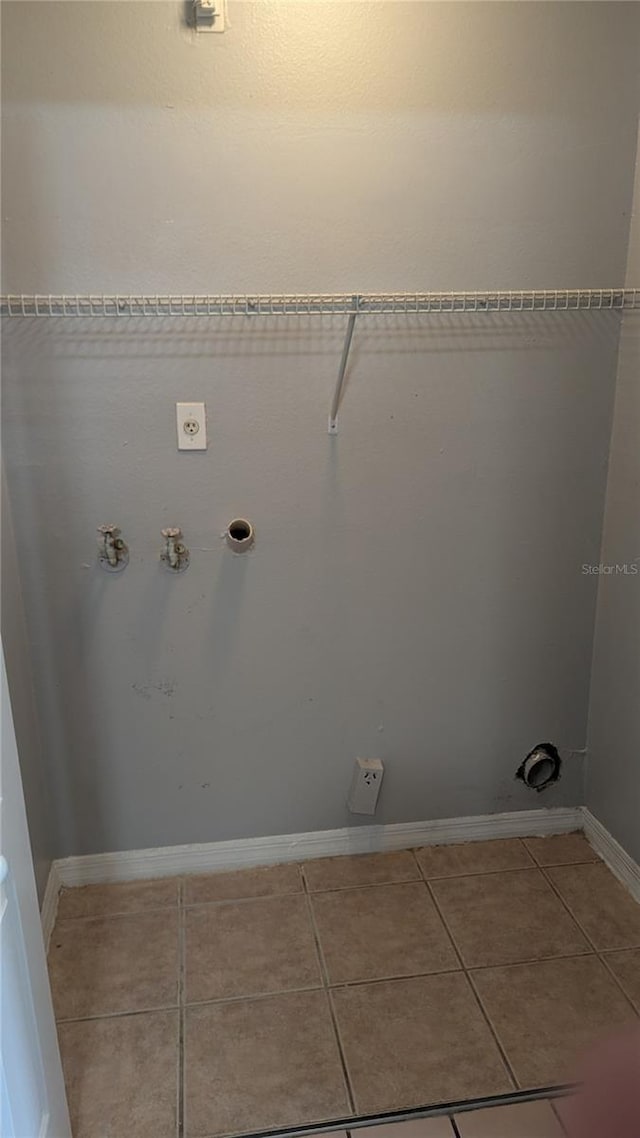 clothes washing area with hookup for a gas dryer and tile patterned flooring