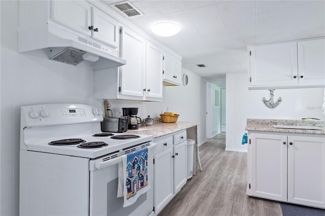 kitchen with light stone countertops, light wood-type flooring, sink, electric stove, and white cabinetry