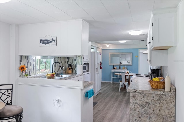 kitchen with kitchen peninsula, light wood-type flooring, sink, white refrigerator with ice dispenser, and white cabinets