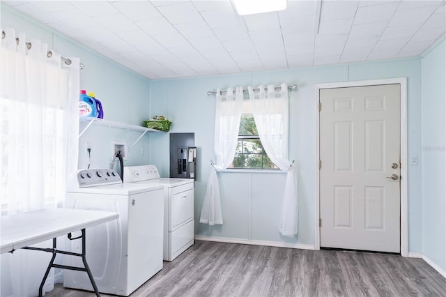 clothes washing area featuring light hardwood / wood-style flooring and washing machine and clothes dryer