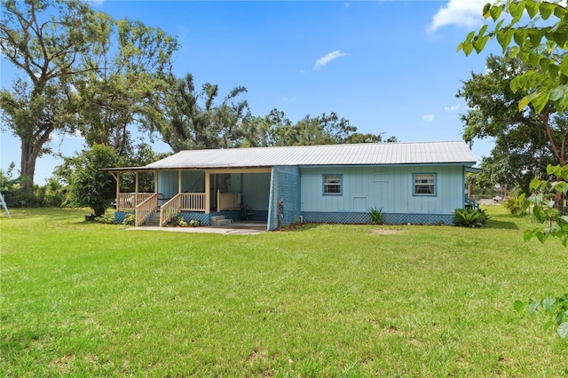 rear view of house with a sunroom and a lawn