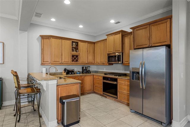 kitchen with a breakfast bar, sink, appliances with stainless steel finishes, kitchen peninsula, and light stone countertops