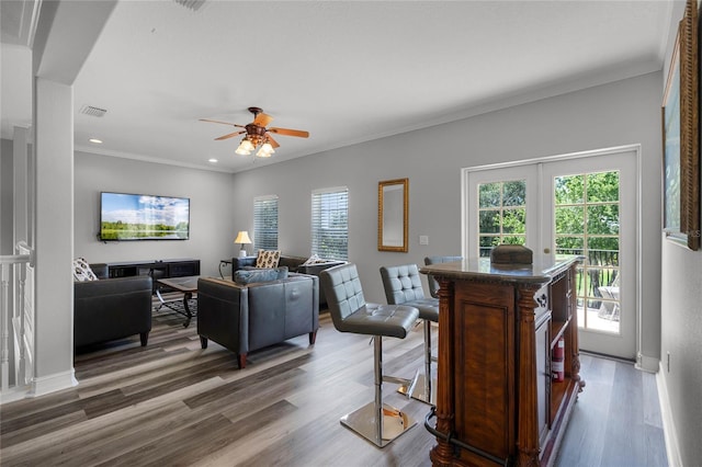 living room with crown molding, dark wood-type flooring, french doors, and ceiling fan