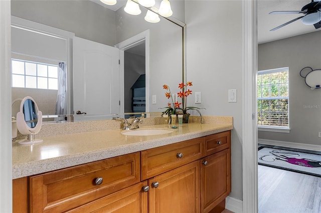 bathroom with hardwood / wood-style flooring, ceiling fan, and vanity