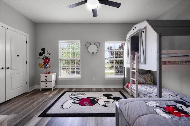 bedroom with multiple windows, wood-type flooring, and ceiling fan