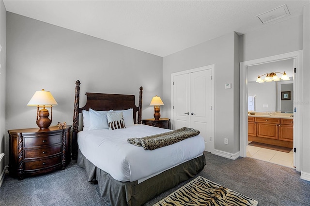 carpeted bedroom with a closet and ensuite bathroom