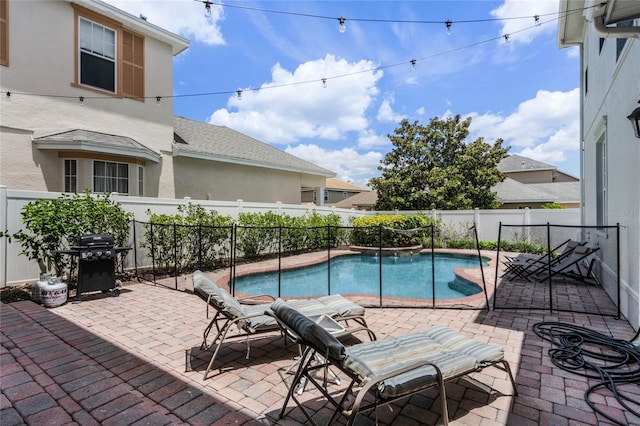 view of pool with a grill and a patio area