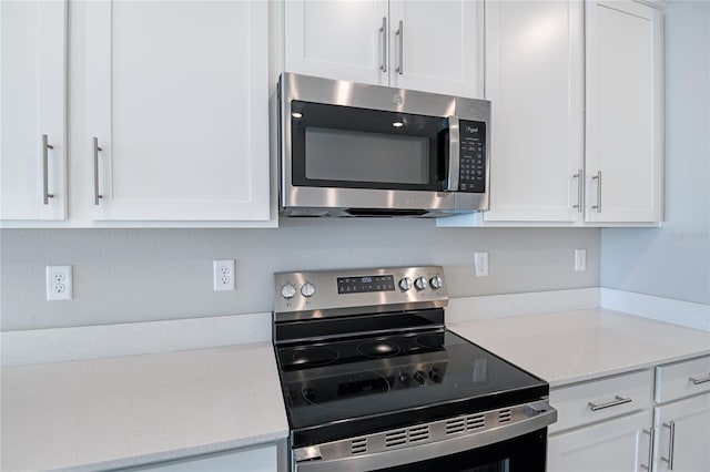 kitchen featuring light stone counters, white cabinetry, and stainless steel appliances