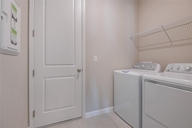 laundry room with washer and dryer and light tile patterned floors