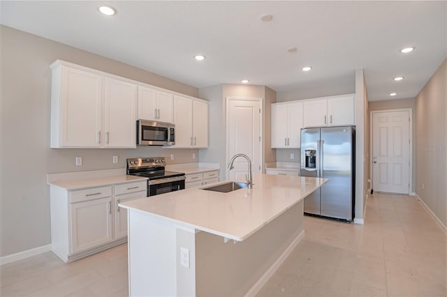 kitchen featuring white cabinets, appliances with stainless steel finishes, an island with sink, and sink