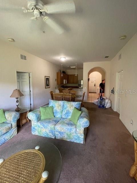 living room featuring carpet and ceiling fan