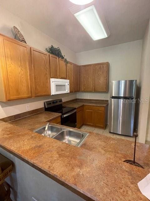 kitchen featuring stainless steel fridge, sink, electric range oven, and light tile patterned floors