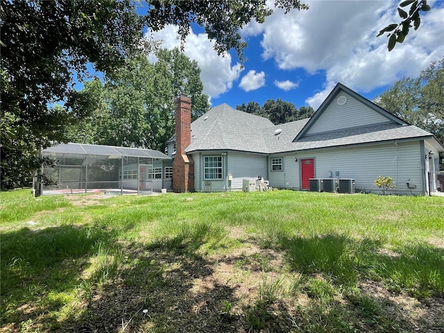 back of property with a swimming pool and glass enclosure