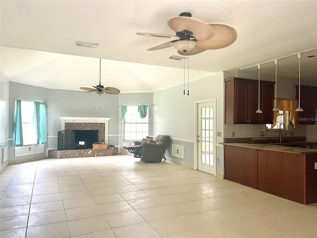 unfurnished living room featuring vaulted ceiling, a fireplace, ceiling fan, and light tile patterned floors