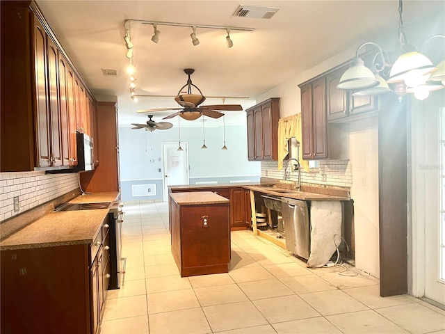 kitchen featuring stainless steel appliances, ceiling fan, backsplash, and a center island