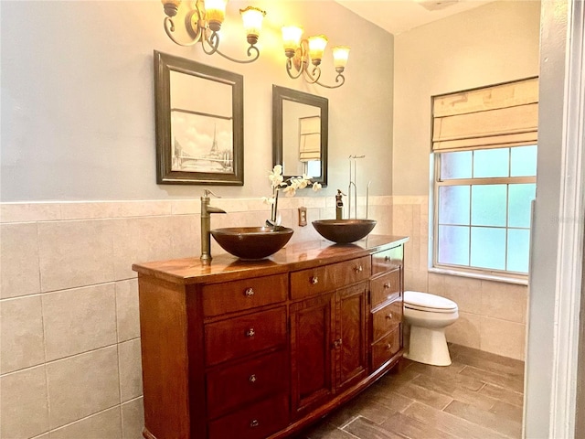 bathroom featuring tile walls, toilet, and vanity