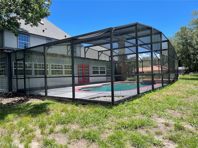 exterior space featuring french doors, glass enclosure, a yard, and a patio area