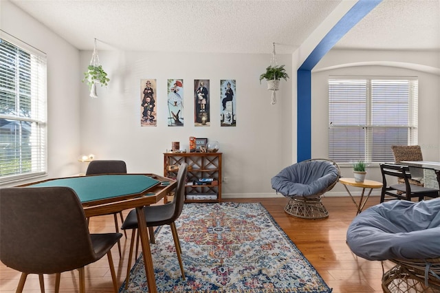 dining area with a textured ceiling and hardwood / wood-style flooring