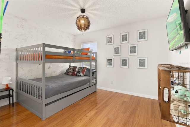 bedroom featuring hardwood / wood-style floors and a textured ceiling