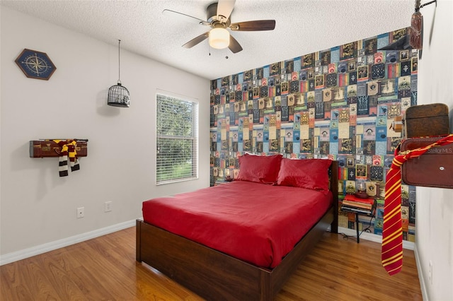 bedroom with ceiling fan, a textured ceiling, and hardwood / wood-style flooring