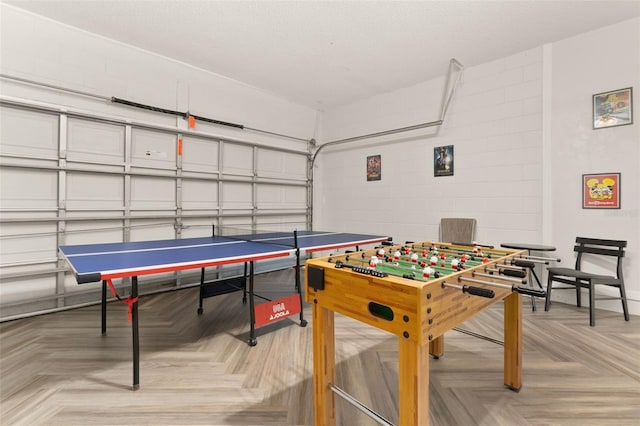 game room with a textured ceiling and light parquet floors