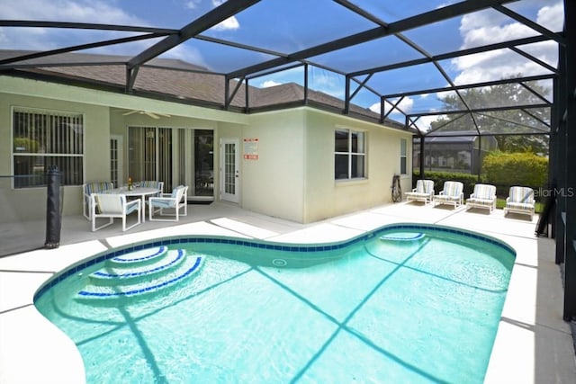 view of pool with a patio, ceiling fan, and a lanai