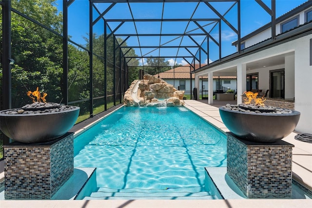 view of pool featuring glass enclosure, pool water feature, and a patio area