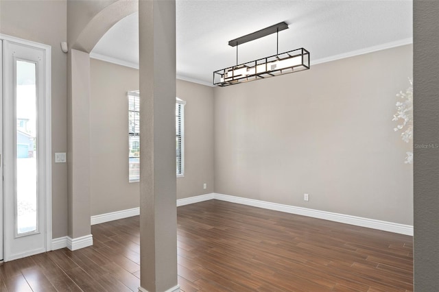 entryway with baseboards, arched walkways, dark wood-style flooring, and ornamental molding