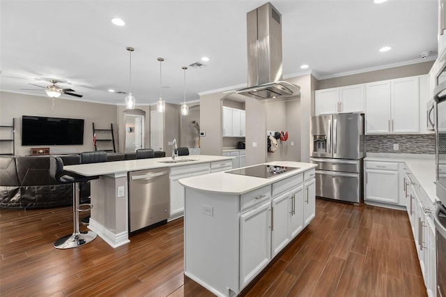 kitchen with a kitchen island, arched walkways, a sink, appliances with stainless steel finishes, and island range hood