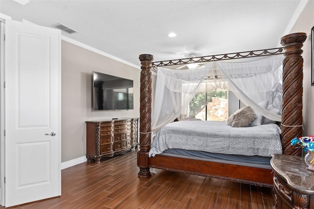 bedroom with visible vents, baseboards, wood finished floors, and ornamental molding