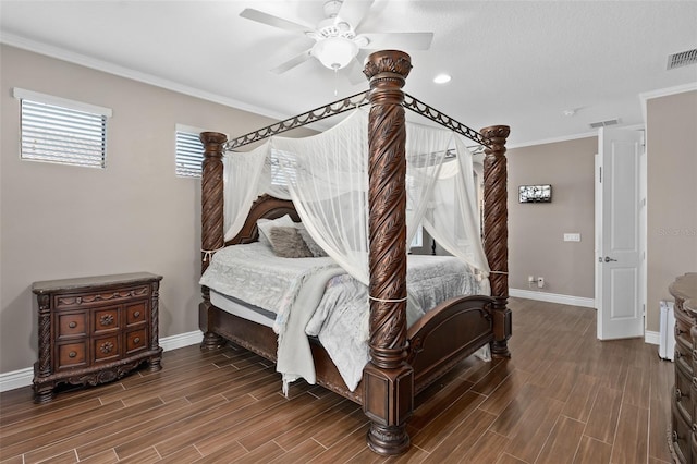 bedroom with visible vents, baseboards, wood finish floors, ornamental molding, and a ceiling fan