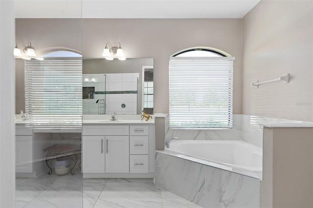 bathroom with vanity and tiled tub