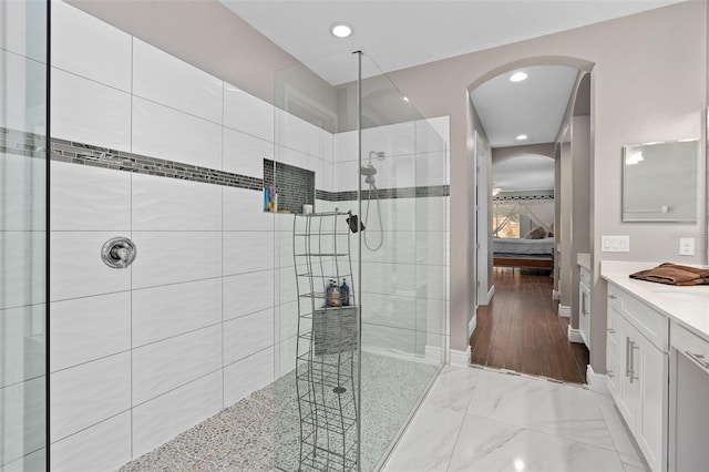 ensuite bathroom featuring baseboards, vanity, ensuite bathroom, and a walk in shower