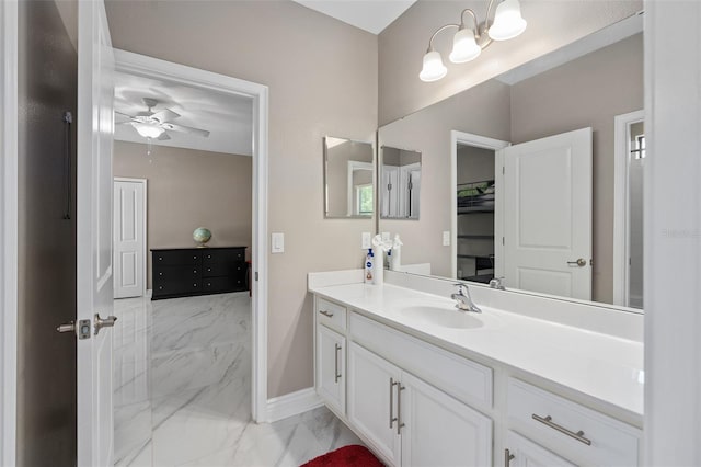 bathroom featuring baseboards, marble finish floor, vanity, and ceiling fan with notable chandelier