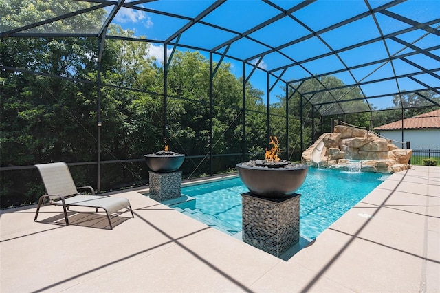 view of pool with pool water feature, glass enclosure, and a patio area