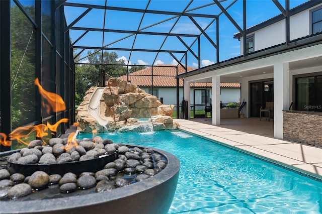 pool featuring glass enclosure, a patio, and a water slide