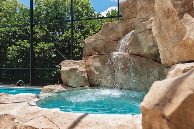 view of swimming pool with pool water feature